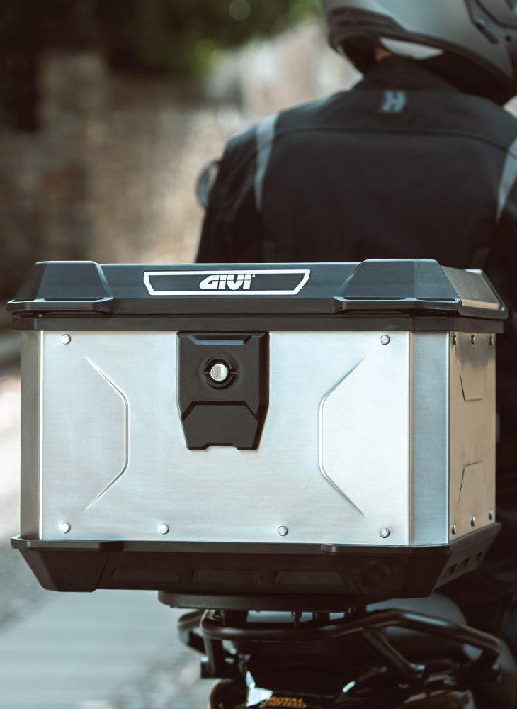 A range of GIVI Monokey and Monolock motorcycle top boxes mounted on a touring bike, showcasing durable storage solutions.